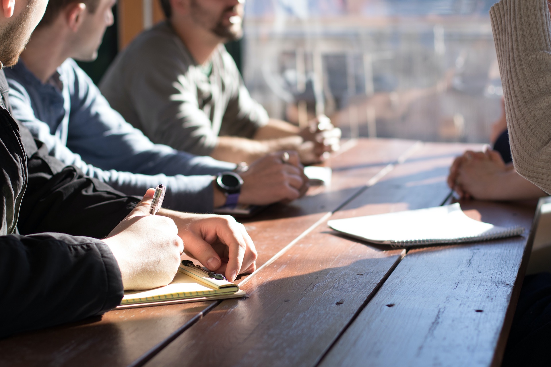 people taking notes and discussing on conference table